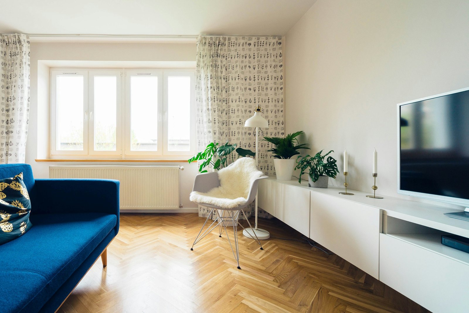 A warm, styled living room with a comfortable sofa, wood coffee table, layered rug and soft lamp light.